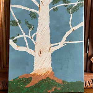 Puede incluir: Pintura acrílica de un árbol con tronco y ramas texturizadas de color blanquecino sobre un fondo azul. El follaje verde acentúa las ramas. La base del árbol es marrón y verde.