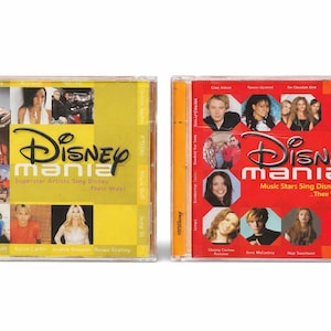 Puede incluir: Dos estuches de CD para los álbumes "Disney Mania". El primer álbum tiene una portada amarilla con el texto "Disney Mania" y "Superstar Artists Sing Disney...Their Way!". El segundo álbum tiene una portada roja con "Disney Mania 3".
