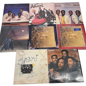 May include: A collection of vinyl records featuring The Winans and Anita Baker. Album covers display images of the artists and album titles. The records are in various colors, including blue, gold, and red, and are sealed in plastic.