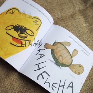 May include: A yellow hyena with a wide open mouth and sharp teeth laughs at a brown and green tortoise that is rolling on its back. The text "Next Little Hyena saw Tortoise struggling to get to his feet... but he just watched him rolling around and chuckled." is written on the page.