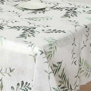May include: White tablecloth with a delicate green leaf pattern. The leaves are painted in shades of green and arranged in a repeating pattern across the fabric. A white plate and silverware are visible on the table.