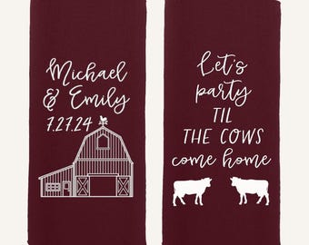 May include: Two maroon slim can coolers featuring white printed graphics. One cooler displays the names Michael & Emily, the date 7.27.24, and a barn illustration. The other cooler features the text Let's party TIL THE COWS come home with two cows.