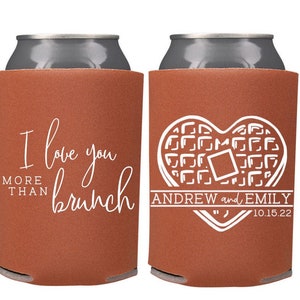 Pu&ograve; includere: Due refrigeratori per lattine marroni con testo bianco. Un refrigeratore dice "Ti amo pi&ugrave; del brunch". L'altro refrigeratore ha un design a forma di cuore di waffle e dice "Andrew ed Emily 10.15.22".