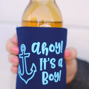 May include: A blue and white can cooler with an anchor and the text "Ahoy! It's a Boy!"