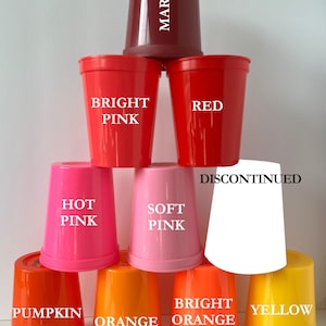 Op de afbeelding: Een piramidevormige opstelling van negen plastic bekers in verschillende kleuren. De bekers zijn voorzien van de tekst: Maroon, Bright Pink, Red, Hot Pink, Soft Pink, Discontinued, Pumpkin, Orange, Bright Orange en Yellow. Elke beker is glad.