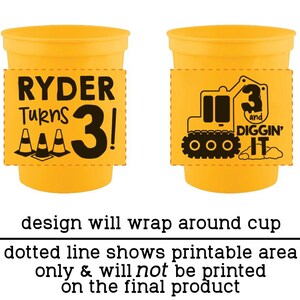 Op de afbeelding: Twee gele plastic bekers met zwarte grafische ontwerpen. E&eacute;n beker toont de tekst RYDER Turns 3! met verkeerskegels. De andere beker toont een graafmachine met de tekst 3 and DIGGIN' IT. Het ontwerp loopt rondom de beker.