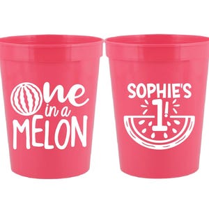Op de afbeelding: Twee roze plastic bekers met watermeloenontwerpen. De ene beker zegt "one in a melon" en de andere zegt "Sophie's 1!"