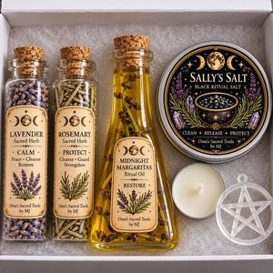 May include: A gift box containing two glass vials filled with lavender and rosemary, a triangular glass bottle of Midnight Margaritas ritual oil, a round tin of Sally's Salt black ritual salt, a white tea light candle, and a clear pentagram charm.