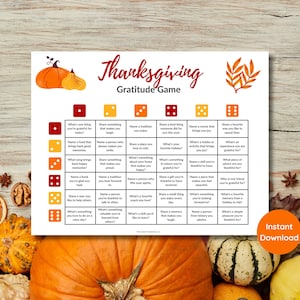 May include: Thanksgiving Gratitude Game printable with orange pumpkins and fall leaves. The game board features a grid with prompts like "What's one thing you're grateful for today?" and "Share a kind thing someone did for you this year."