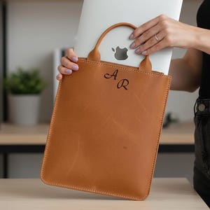 Puede incluir: Una taza de cerámica blanca con asa negra y el texto "But First, Coffee" en negro, en negrita. La taza está sobre una superficie blanca.