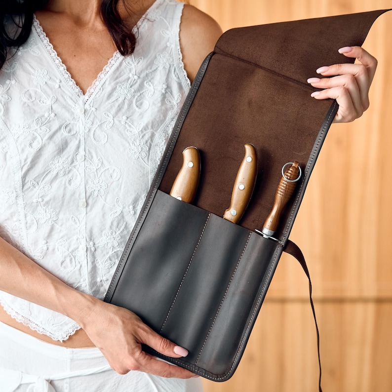 Carry your knives in style with our Custom Leather Knife Roll – a durable, handmade leather case designed for chefs and food lovers. This chef knife roll leather features multiple slots, secure buckle closure, and optional personalization. Perfect for safe transport and stylish storage. A great gift for culinary pros. Upgrade your gear today with this sleek knife storage roll!