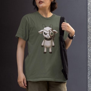 Puede incluir: Camiseta verde oliva con una ilustración de dibujos animados de una oveja blanca con un solo ojo grande, inyectado en sangre y cuernos. La oveja tiene una expresión severa y lleva un collar marrón. La camiseta es de estilo casual.