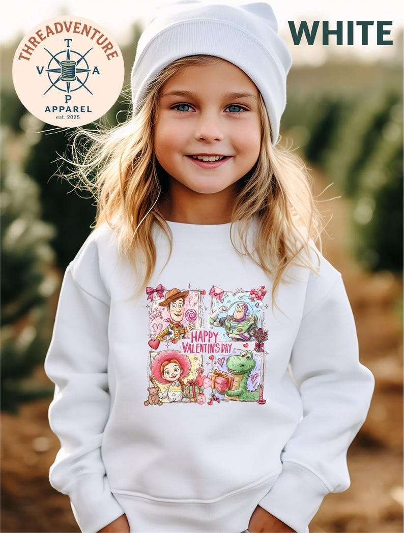 A young girl wearing a white sweater with a colorful graphic of characters from Toy Story and Happy Valentine's Day.