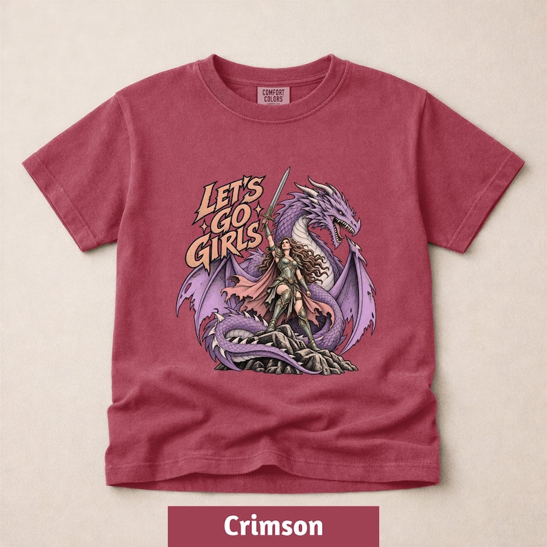A red t-shirt with a graphic design depicting a woman with long hair and a dragon on her back, along with the text "Let's go girls".