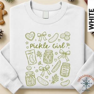 A white long-sleeved shirt with a graphic design featuring various pickle-related items such as jars, a jar of pickles, and a heart.