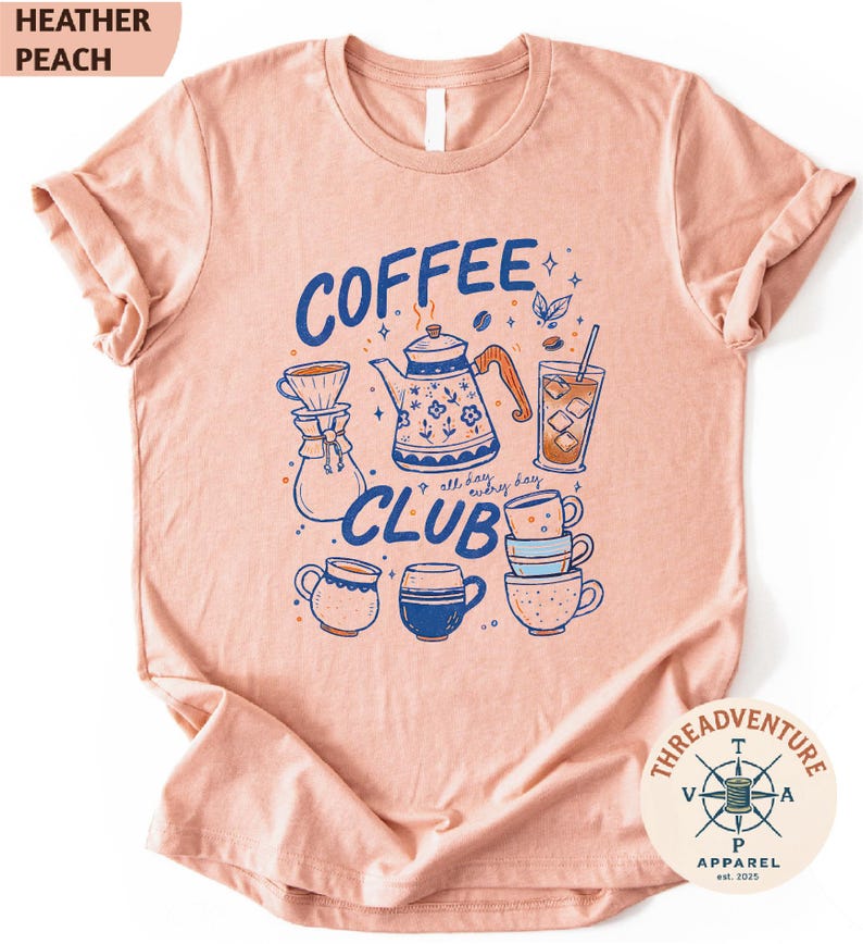The image is a pink t-shirt with a graphic design featuring various coffee-related items such as a coffee pot, coffee cup, and coffee mug, along with the text "COFFEE CLUB" and "THREAD ADVENTURE APPAREL" printed on it.