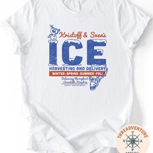 A white t-shirt with a graphic design featuring text and illustrations related to Kristoff and Suen's Ice.