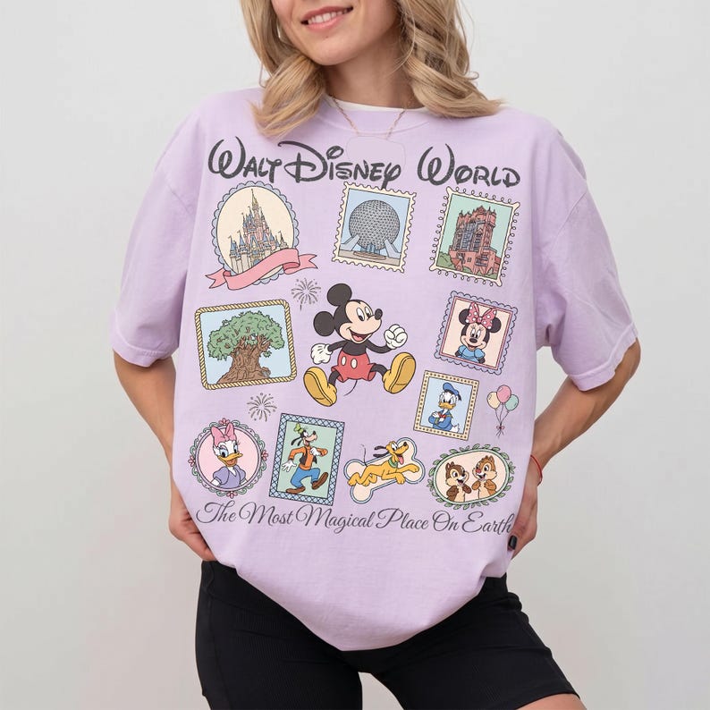 May include: A light purple t-shirt featuring a collage of Disney characters and landmarks. The shirt includes images of Mickey and Minnie Mouse, Donald Duck, and Chip and Dale. Text on the shirt reads "Walt Disney World" and "The Most Magical Place On Earth."
