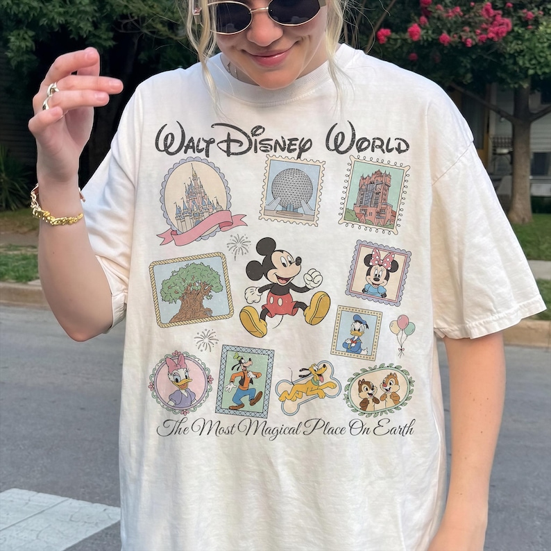May include: Cream-colored Walt Disney World t-shirt featuring various Disney characters and park icons in a postage stamp design. The shirt includes Mickey Mouse, Minnie Mouse, Donald Duck, and Chip and Dale. Text reads "Walt Disney World" and "The Most Magical Place On Earth."