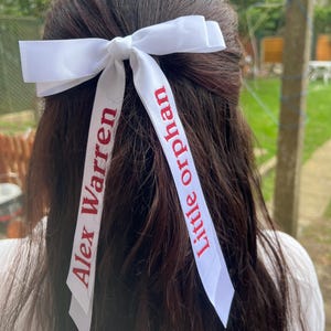 以下が含まれることがあります： 手作りの木製ウェルカムサイン。手書き風の「Welcome」の文字。白く塗装され、かすれた仕上がり。上部には小さな緑の葉が飾られています。屋内または屋外での使用に適しています。