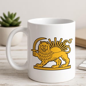 May include: White ceramic mug with a gold lion and sunburst design. The lion holds a sword and stands on a gold base. The mug has a white handle. The mug is on a wooden surface.