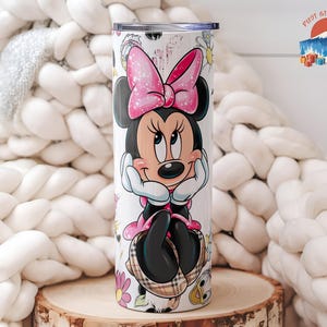 May include: A white tumbler featuring a Minnie Mouse design. Minnie is depicted with a pink bow, black ears, and a black dress. The tumbler has a silver lid and is decorated with flowers and a plaid pattern.