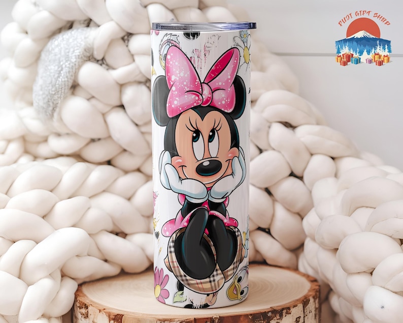 May include: A white tumbler featuring a Minnie Mouse design. Minnie is depicted with a pink bow, black ears, and a black dress. The tumbler has a silver lid and is decorated with flowers and a plaid pattern.