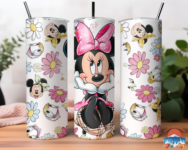 May include: A set of three white stainless steel tumblers featuring a Minnie Mouse design. The center tumbler showcases Minnie with a pink bow. The other two tumblers have a pattern of flowers, Minnie, and Donald Duck.