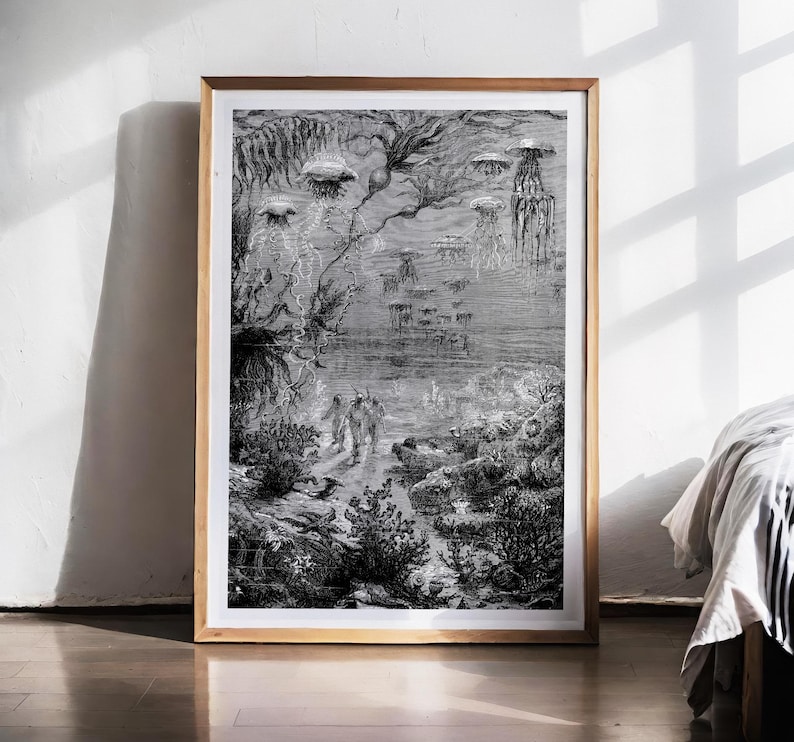 May include: Black and white framed print of an underwater scene with jellyfish and figures. The detailed illustration depicts a dark, mysterious ocean environment with various marine life and plant life. The artwork is framed in a light brown wooden frame.