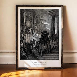 Peut inclure: Impression encadrée en noir et blanc d'une gravure détaillée représentant un rassemblement de personnages dans une grande salle. Le texte "SATAN EN CONSEIL" figure au bas de l'impression.