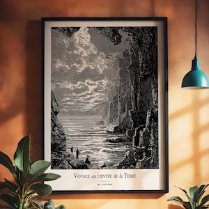 Könnte beinhalten: Schwarz-Weiß-Druck in einem Rahmen, der eine Küstenlandschaft mit Figuren zeigt. Das Kunstwerk mit dem Titel "Voyage au Centre de la Terre" von Jules Verne zeigt Klippen, Meer und Himmel. Der Druck befindet sich in einem schwarzen Rahmen.
