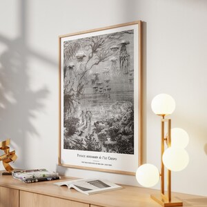 May include: A framed black and white illustration depicting an underwater scene with jellyfish and figures. The artwork, titled "Paysage Sous-Marin de l'Ile Crespo," is displayed on a wooden table with a modern lamp and decorative items.