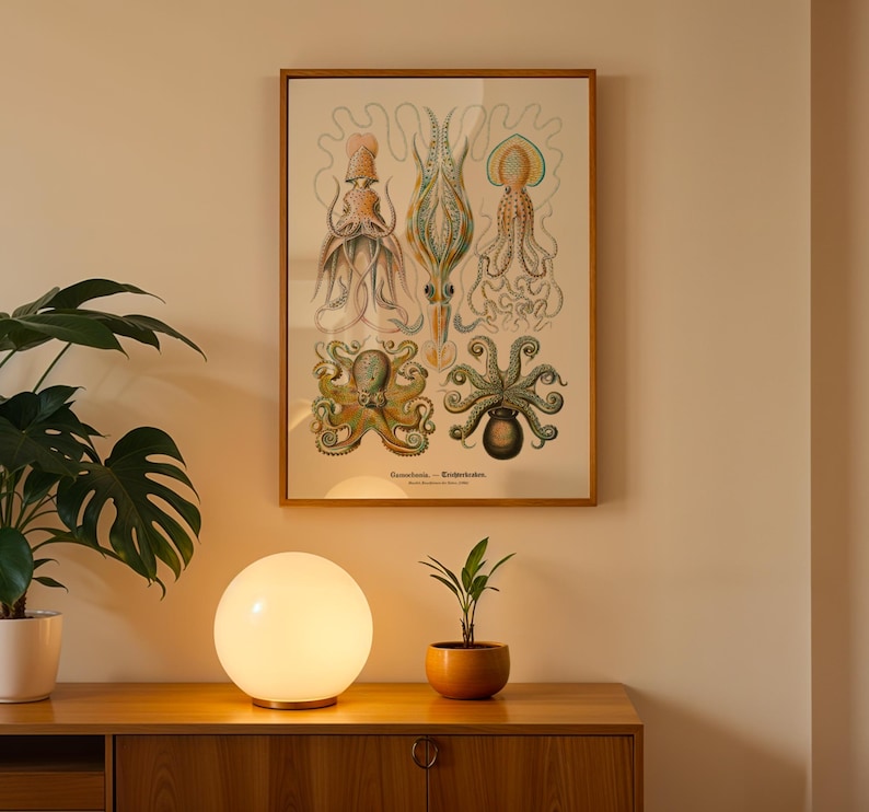 May include: A framed vintage print featuring detailed illustrations of various octopus species in shades of orange, green, and blue. The print is displayed above a wooden cabinet, with a glowing spherical lamp and a potted plant in front.