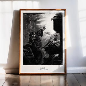 Peut inclure: Impression encadrée en noir et blanc d'une illustration de Faust. L'œuvre représente une figure vêtue d'une robe avec un bras tendu, un squelette et divers objets. L'impression est dans un cadre en bois et est posée contre un mur blanc.