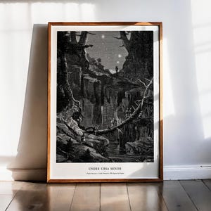 May include: A framed black and white art print titled UNDER URSA MINOR. The illustration depicts a dark, rocky gorge with tall trees and figures crossing a fallen log bridge under a starry night sky. The print is encased in a simple wooden frame.