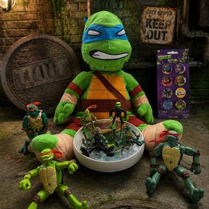 May include: A large plush Leonardo toy with a blue mask, surrounded by several smaller Teenage Mutant Ninja Turtles action figures, a white bowl containing miniature figures, and a retail card featuring eight circular character buttons.