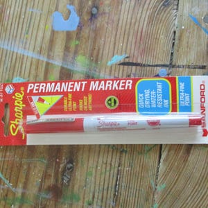 以下が含まれることがあります： ウルトラファインポイントを備えた赤いSharpie永久マーカーで、オリジナルの小売パッケージに入っています。カードには赤、白、青のグラフィックがあり、Permanent Marker、Quick Drying、Water-Resistant Ink、Sanfordなどのテキストが記載されています。