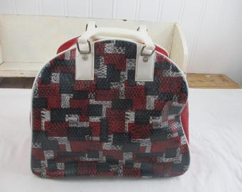 Bolsa/estuche vintage para bolas de bolos Brunswick, color granate, blanco y negro con jaula metálica interior para la bola. Pequeña grieta en el vinilo cerca de una de las asas.