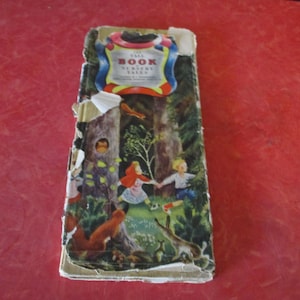 May include: Vintage children's book titled "Tall Book Nursery Tales." The cover features a colorful illustration of a forest scene with figures and animals. The book's edges show signs of wear and tear.