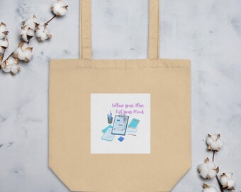 Könnte beinhalten: Eine beige Tragetasche mit einem weißen quadratischen Design, das ein motivierendes Zitat zeigt: "Folge deinem Plan - Nicht deiner Stimmung." Das Design enthält auch einen blau-weißen Planer, einen Bleistift und andere Büroartikel.