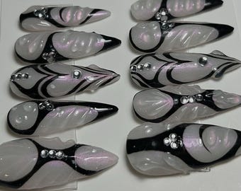 May include: Ten white and black swirl patterned false nails with rhinestones.