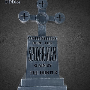 May include: A gray, stylized tombstone with a cross-shaped top. The text "HERE LIES SPIDER-MAN SLAIN BY THE HUNTER" is engraved on the front. The tombstone has a weathered appearance, suggesting it is made of stone.