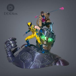 May include: A collectible action figure set featuring Wolverine in a yellow and blue suit and Gambit in a brown trench coat standing atop a large, metallic, purple robotic head with glowing green eyes and a raised mechanical fist.