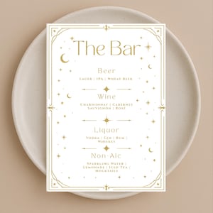 May include: A white rectangular bar menu with gold text and decorative celestial accents. The menu lists beer, wine, liquor, and non-alcoholic beverages. The text "The Bar" is at the top.