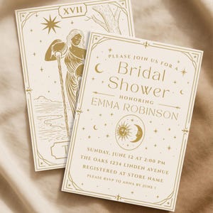 May include: Two ivory-colored bridal shower invitations with gold-colored text and illustrations. One card features a woman pouring water, the other has the text "Bridal Shower" and details. The invitations are decorated with stars, moons, and suns.