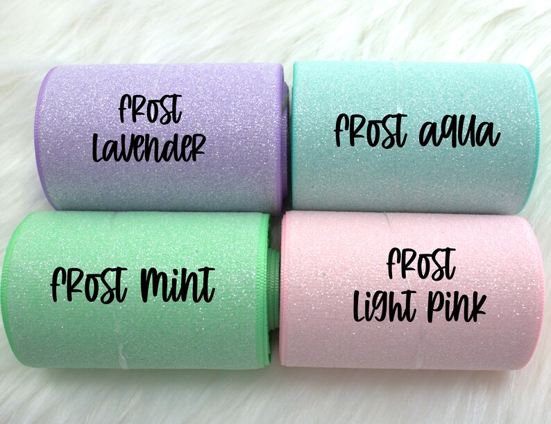 May include: Four rolls of glitter ribbon in different colors: frost lavender, frost aqua, frost mint, and frost light pink.