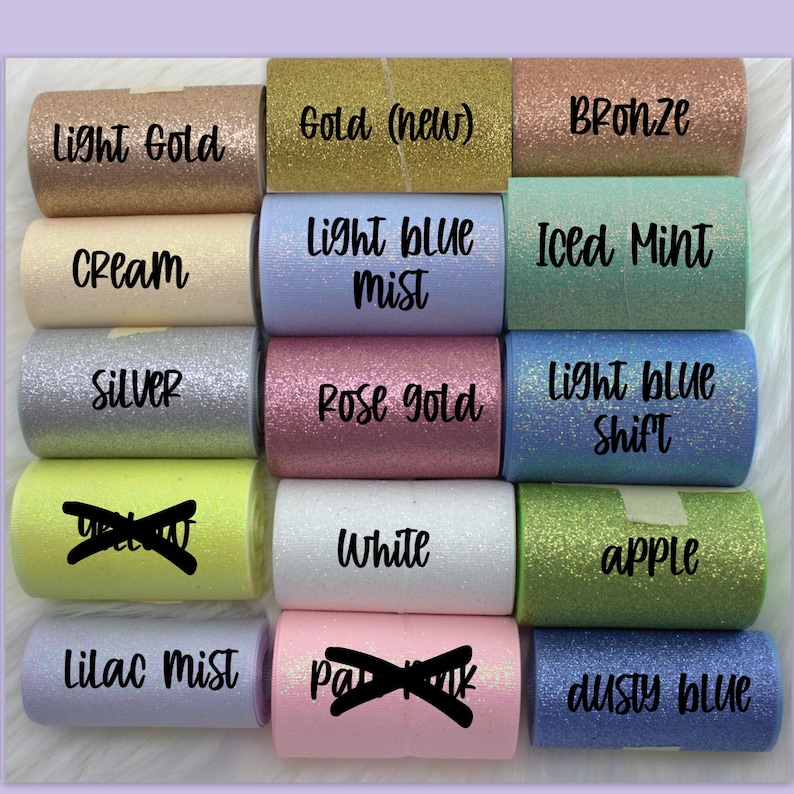 May include: A collection of 12 rolls of glitter ribbon in various colors, including light gold, gold, bronze, cream, light blue mist, iced mint, silver, rose gold, light blue shift, white, apple, lilac mist, dusty blue.