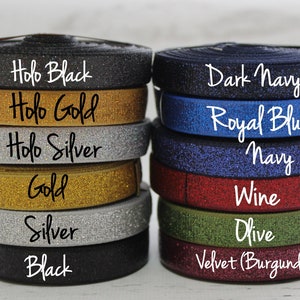 May include: A stack of eight different colored elastic bands with glitter. The colors are: Holo Black, Holo Gold, Holo Silver, Gold, Silver, Black, Dark Navy, Royal Blue, Navy, Wine, Olive, and Velvet (Burgundy).