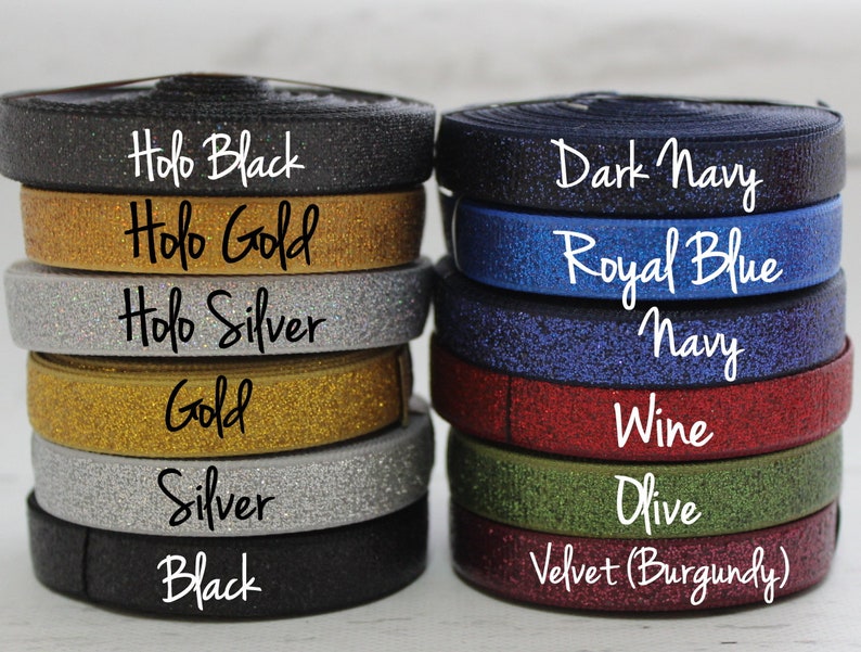 May include: A stack of eight different colored elastic bands with glitter. The colors are: Holo Black, Holo Gold, Holo Silver, Gold, Silver, Black, Dark Navy, Royal Blue, Navy, Wine, Olive, and Velvet (Burgundy).