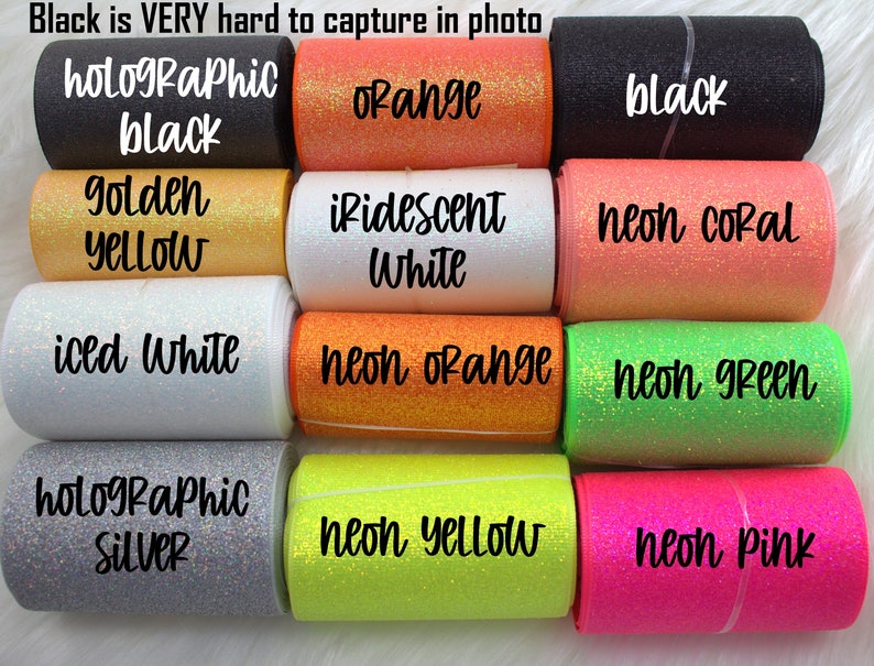 May include: A collection of 12 different colors of glitter ribbon, including holographic black, orange, golden yellow, iridescent white, iced white, holographic silver, neon orange, neon green, neon yellow, neon pink, and neon coral.